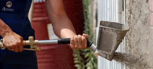 Използване на кофа за пръскане на мазилка върху стена